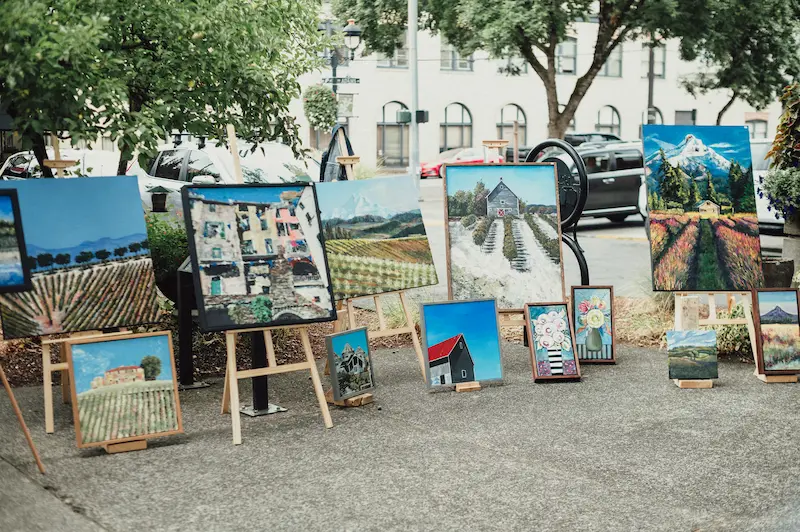 Local landscape paintings displayed on easels during the outdoor Camas Art and Wine Walk in Downtown Camas.