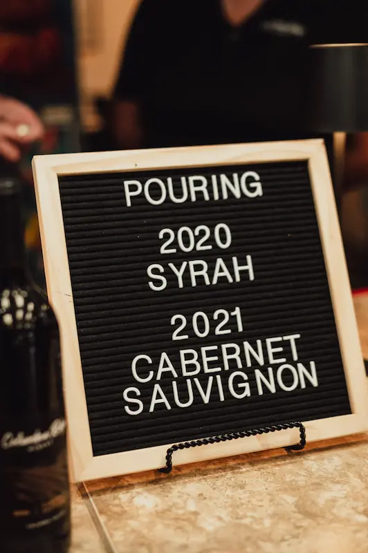 A letter board sign at the Camas Art and Wine Walk showcasing 2020 Syrah and 2021 Cabernet Sauvignon.