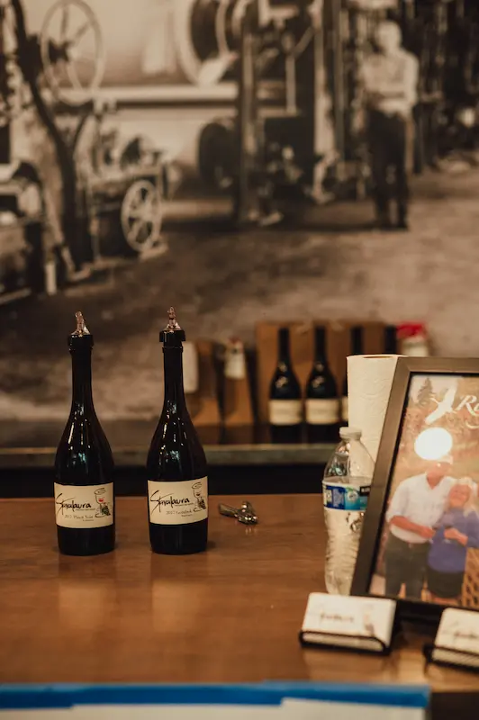 Stavalaura Vineyard wine bottles displayed at a tasting station during the Camas Art and Wine Walk in Washington.